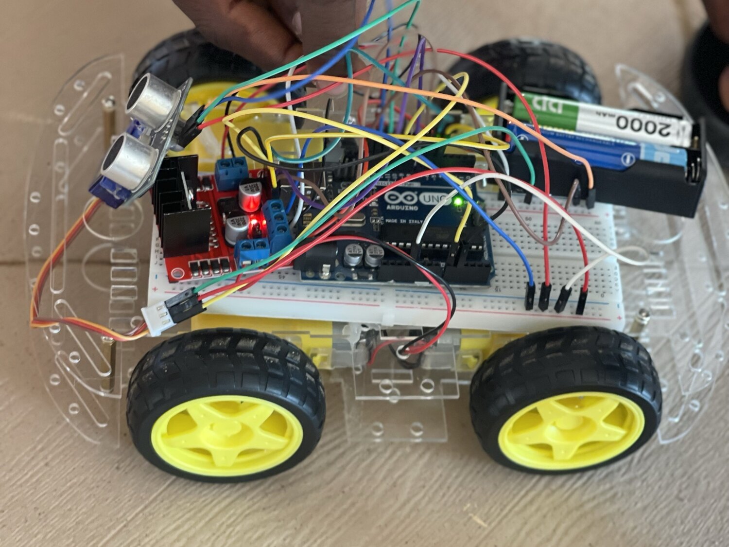 The Arduino, motor driver and ultrasonic sensor wired up on the breadboard for obstacle detection